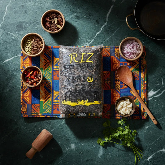 Sachet de Riz Sauvage TERSOL - Riche Nutrition, grains longs fins, posé sur un tissu coloré avec épices et herbes aromatiques.