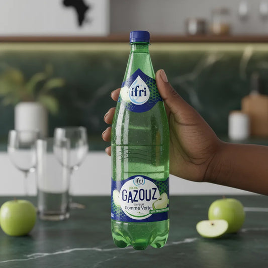 Main tenant une bouteille de Soda Pomme Verte IFRI GAZOUZ, boisson pétillante au goût acidulé, parfaite pour les instants de fraîcheur.