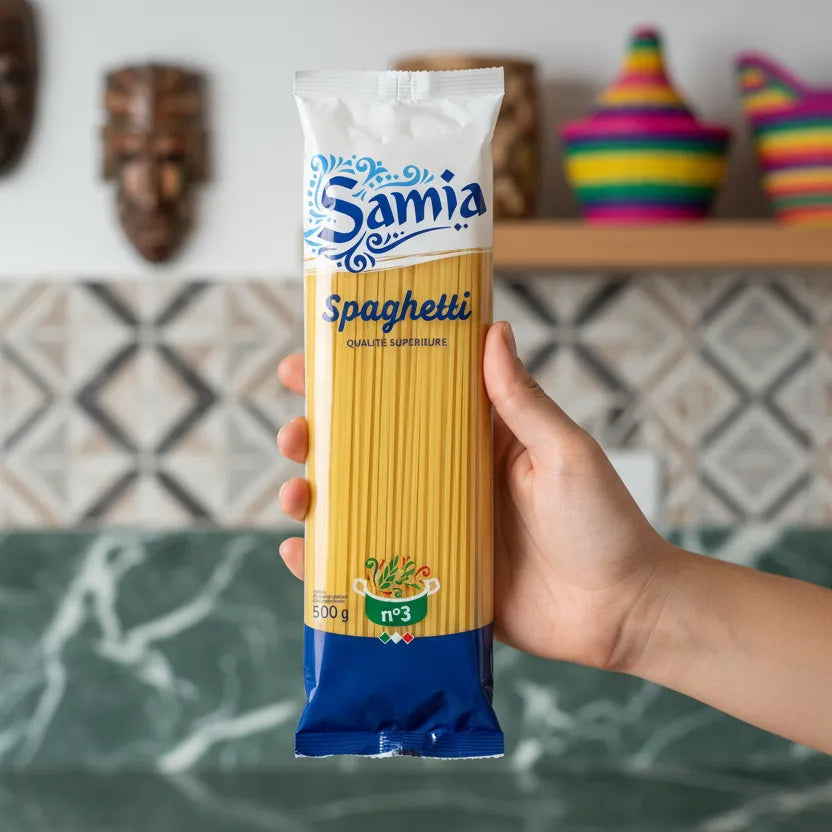 Main tenant un paquet de spaghetti n°3 SAMIA 500g dans une cuisine moderne. Pâtes longues idéales pour des recettes italiennes authentiques.
