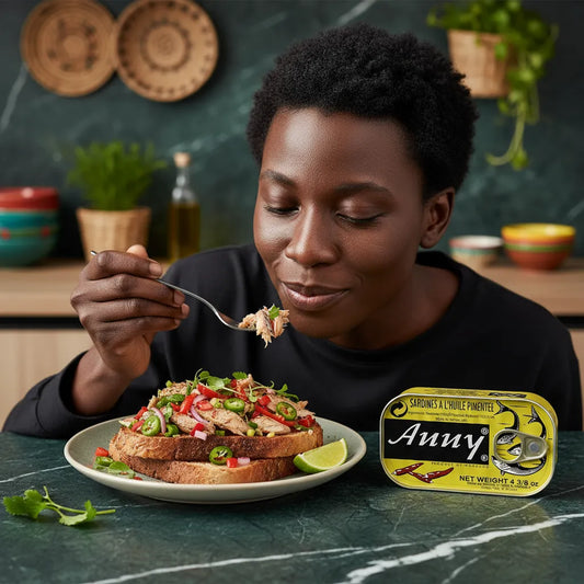 Femme dégustant des tartines garnies de sardines épicées ANNY, mettant en valeur le goût authentique et relevé du produit en cuisine maison.