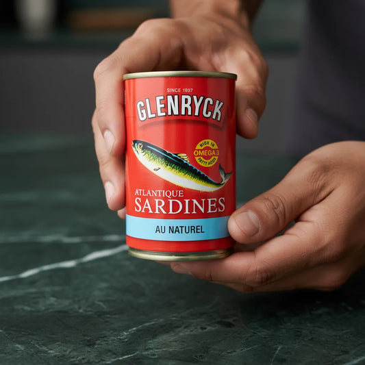 Main tenant une boîte de sardines Glenryc naturelles, mettant en avant leur format pratique et leur qualité pour les rayons de produits de la mer.
