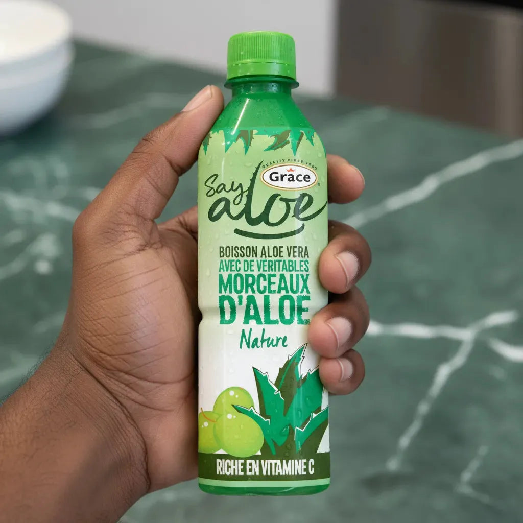 Main tenant une bouteille de jus d'aloe vera GRACE Naturel, boisson à base de véritables morceaux d'aloe, idéale pour une hydratation saine.