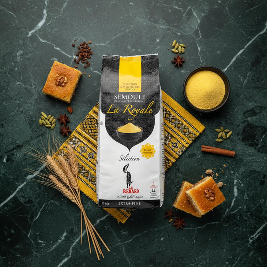 Semoule RENARD Extra-fine La Royale posée sur napperon berbère, entourée de semoule, épices et gâteaux orientaux, idéale pour cuisine variée.