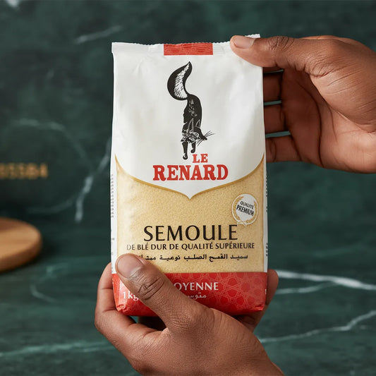 Main tenant un paquet de semoule de blé moyenne RENARD - Polyvalente et Savoureuse, ingrédient essentiel en épicerie salée.