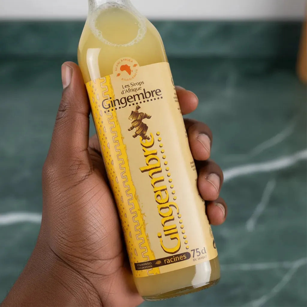 Main tenant une bouteille de jus concentré de gingembre RACINES, boisson naturelle au goût puissant de gingembre, format 75cl.