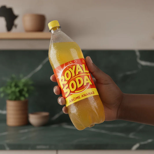 Main tenant une bouteille de ROYAL SODA goût ananas, boisson rafraîchissante idéale pour les amateurs de saveurs tropicales.