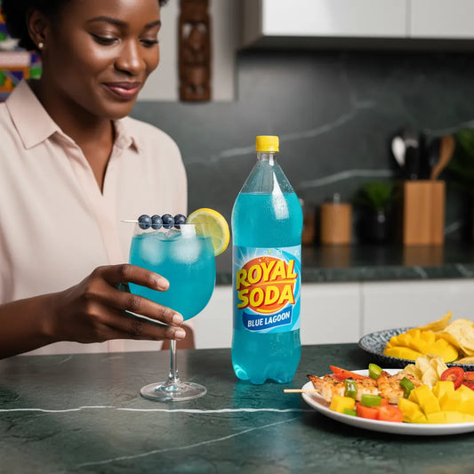 Femme dégustant un cocktail au Soda Blue Lagon ROYAL SODA, boisson pétillante fruitée servie avec des fruits exotiques lors d’un repas convivial.