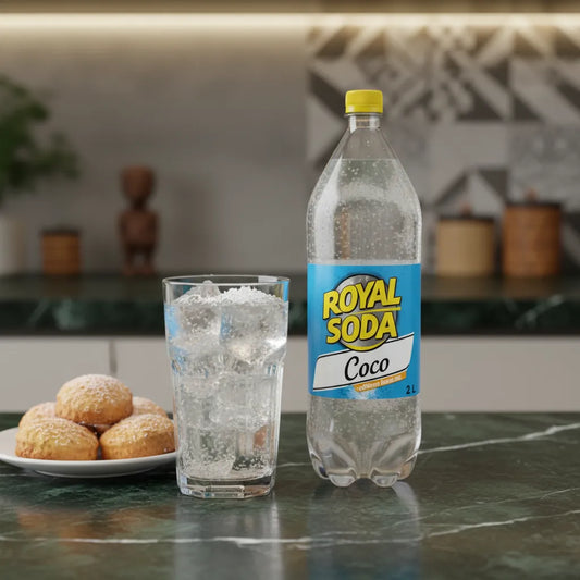 Soda coco ROYAL SODA 2L servi avec glaçons et pâtisseries, boisson rafraîchissante à la noix de coco sur table de cuisine élégante.