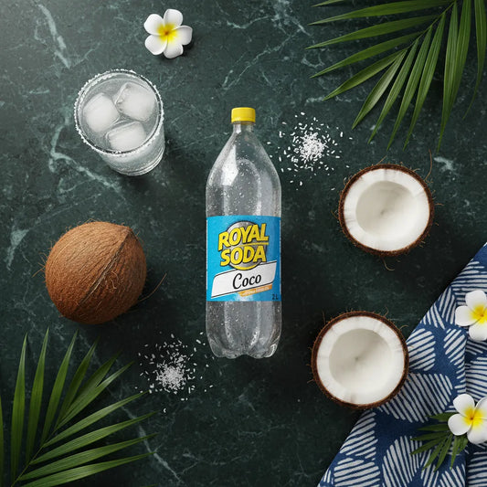 Bouteille de soda coco ROYAL SODA 2L entourée de noix de coco, fleurs et feuilles tropicales, ambiance exotique et rafraîchissante.