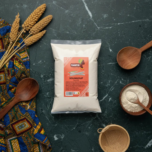 Soungouf TANTIE - Authentique Cuisine | Traditionnelle & Savoureuse, farine de mil présentée avec ustensiles et décor africain sur table de cuisine.