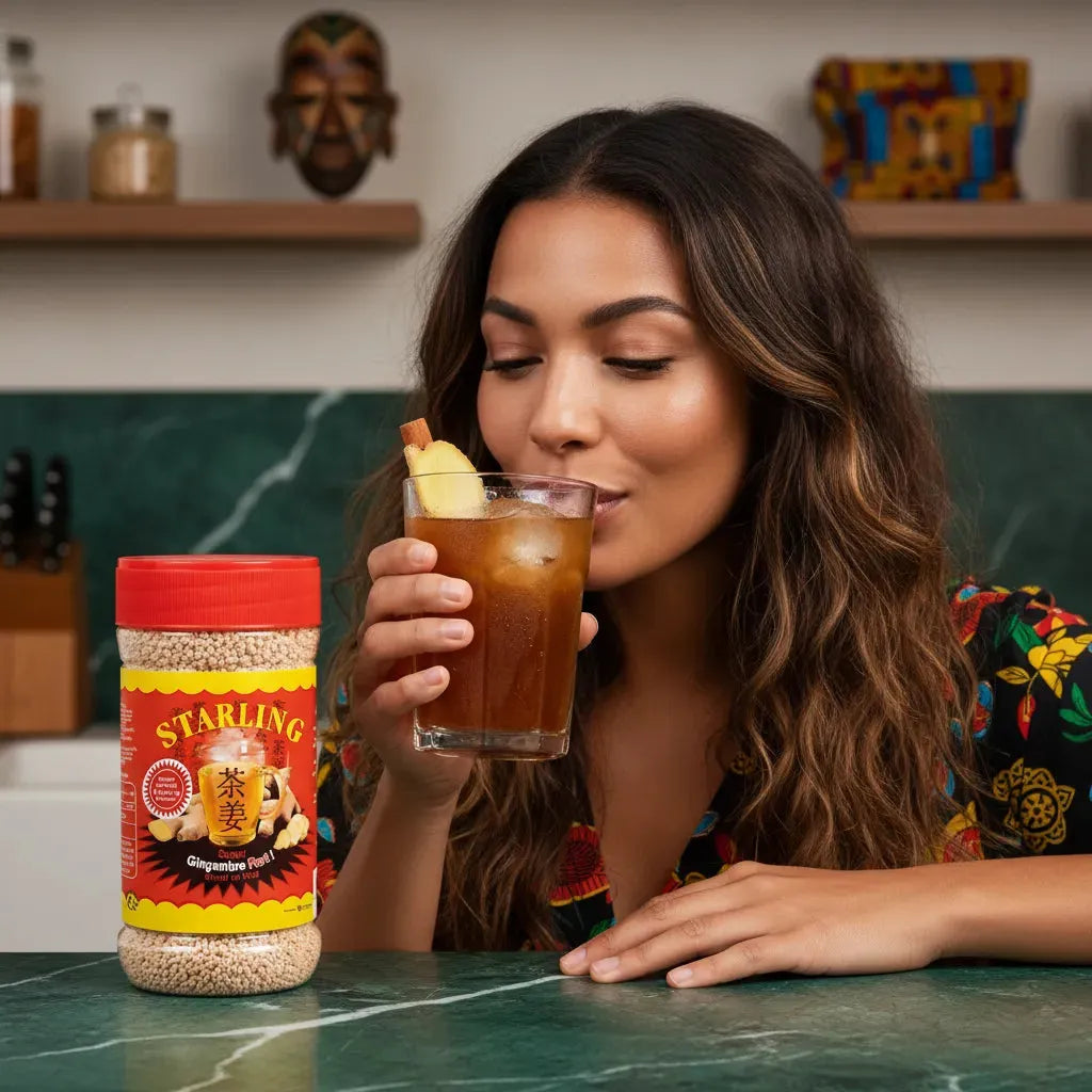 Femme dégustant une boisson glacée au thé au gingembre STARLING, parfait pour une pause fraîcheur. Pot de thé visible sur table de cuisine moderne.