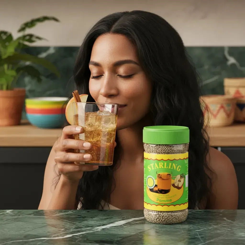 Femme dégustant un verre de thé pomme STARLING glacé, pot de thé instantané visible sur table de cuisine moderne.