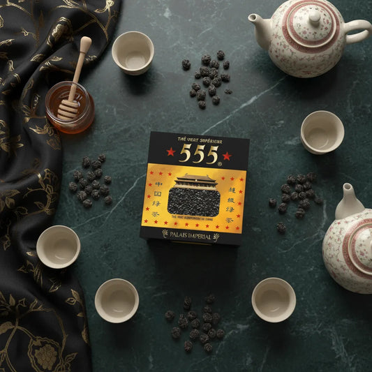 Thé vert Gunpowder Superextra 555 présenté avec service à thé asiatique sur table en marbre, idéal pour une dégustation raffinée.