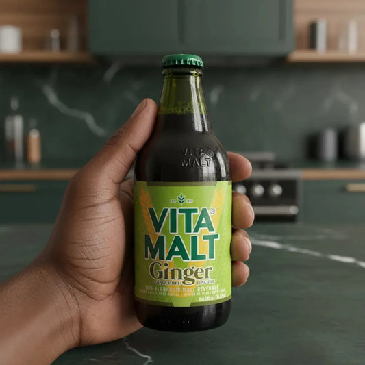 Main tenant une bouteille de VITA MALT Boisson Malt Gingembre, boisson non alcoolisée enrichie en vitamines, goût épicé et revitalisant.