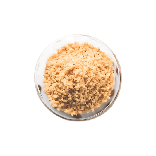 Vue rapprochée d’Akpi moulue dans un bol en verre, épice camerounaise à texture fine pour assaisonner sauces et plats africains.