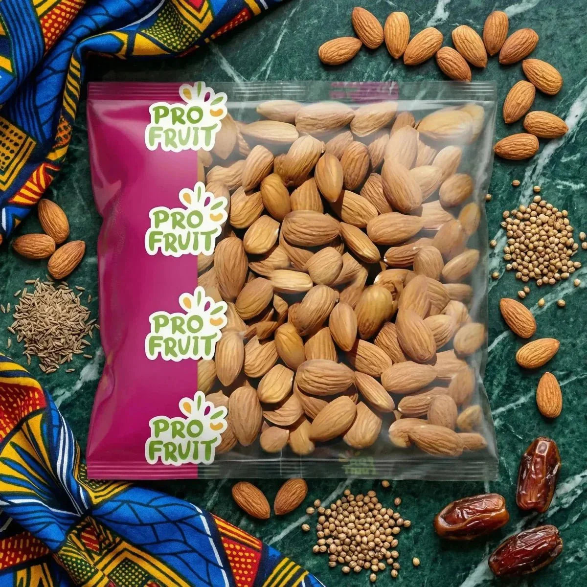 Bag of ProFruit almonds, decoration, seeds, dates, and colorful fabric on a green marbled background.