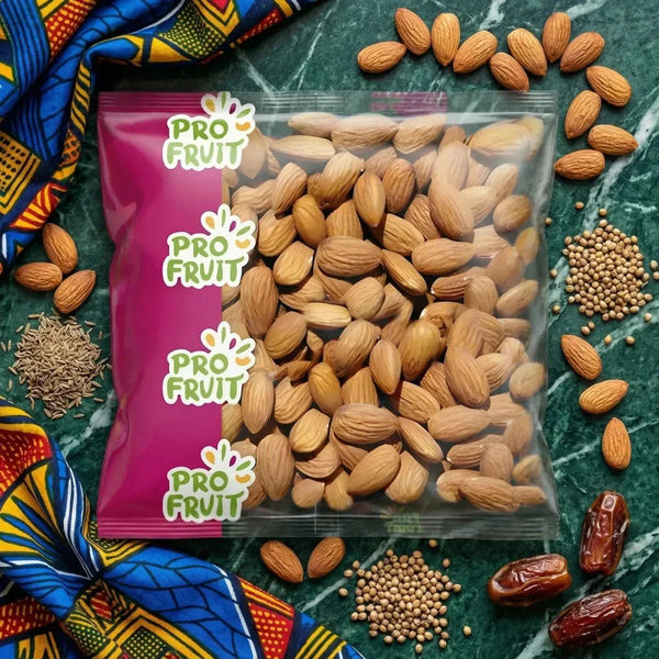 Sachet d'amandes ProFruit, décor, graines, dattes et tissu coloré sur fond marbré vert.