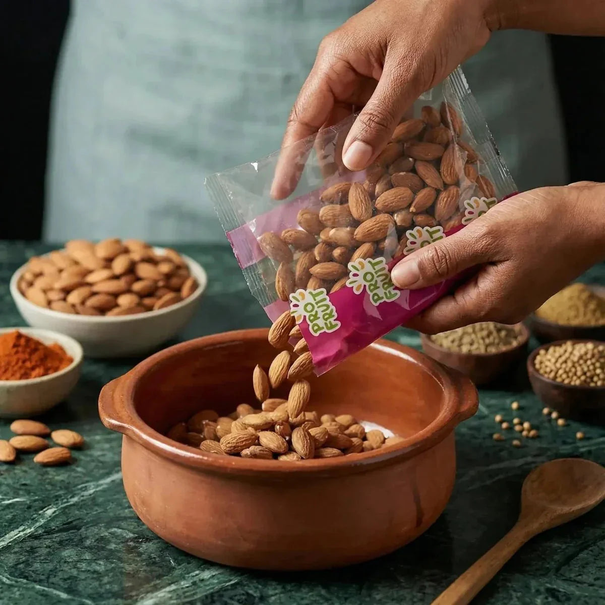 PROFRUIT almonds poured into a clay bowl. Transparent pink and green bag.