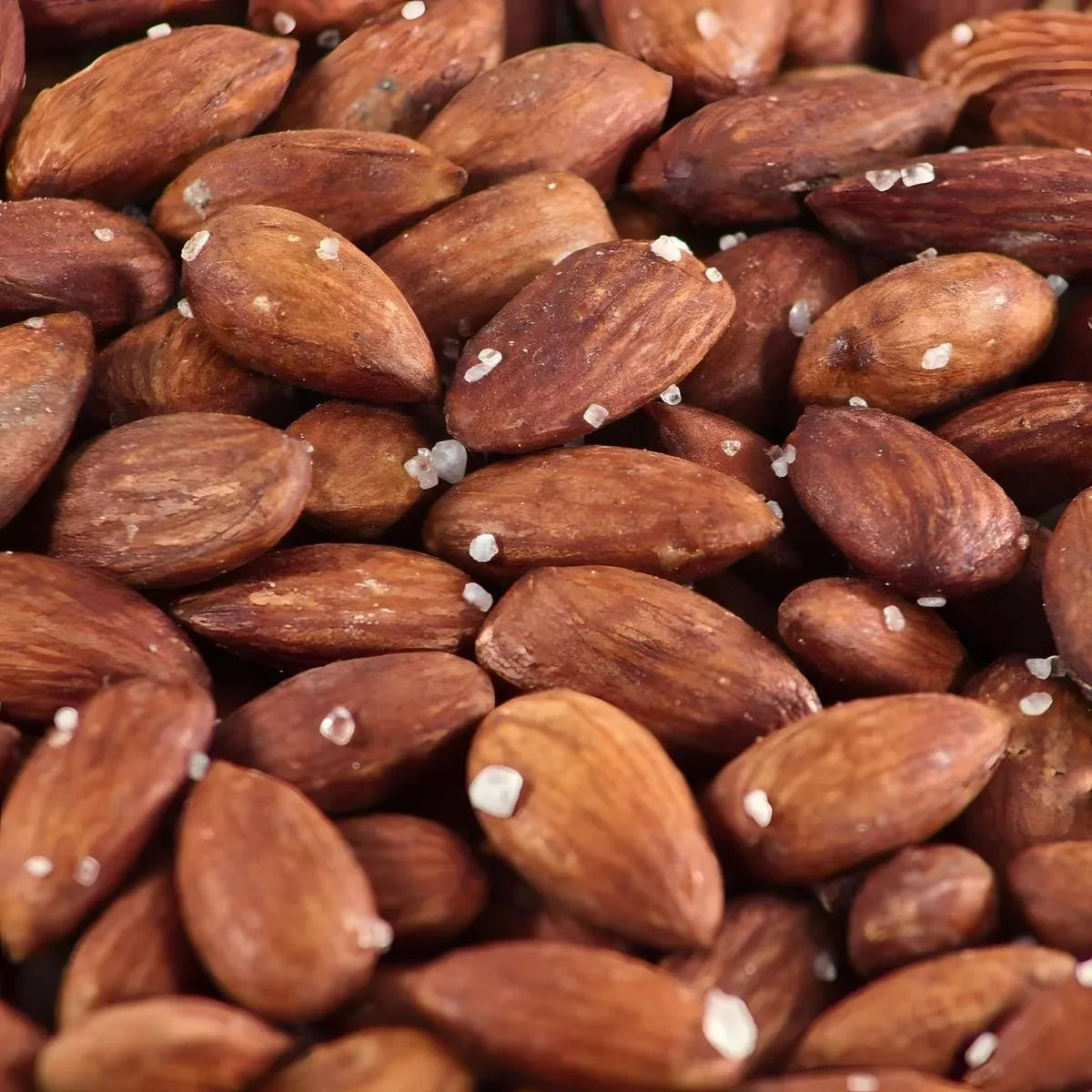 Salted roasted almonds, close-up view. Brown color, visible salt crystals.
