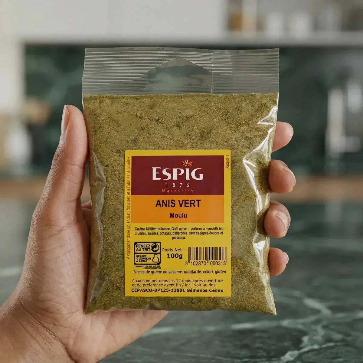 Bustina di anice verde macinato ESPIG 100g tenuta a mano. Confezione gialla e trasparente.