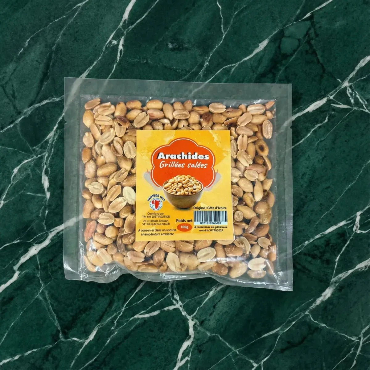 Zak gezouten geroosterde pinda's "Number One" op een groen marmeren achtergrond, transparante verpakking.