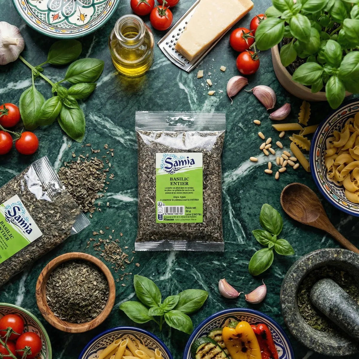 Zak met hele basilicum SAMIA op een groen marmeren achtergrond, omringd door Italiaanse ingrediënten: pasta.