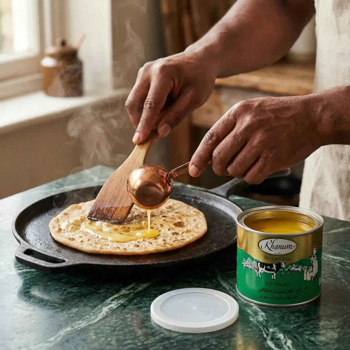 Khanum ghee butter 500g poured over a flatbread. Cook's hand, pan, spatula, open jar.