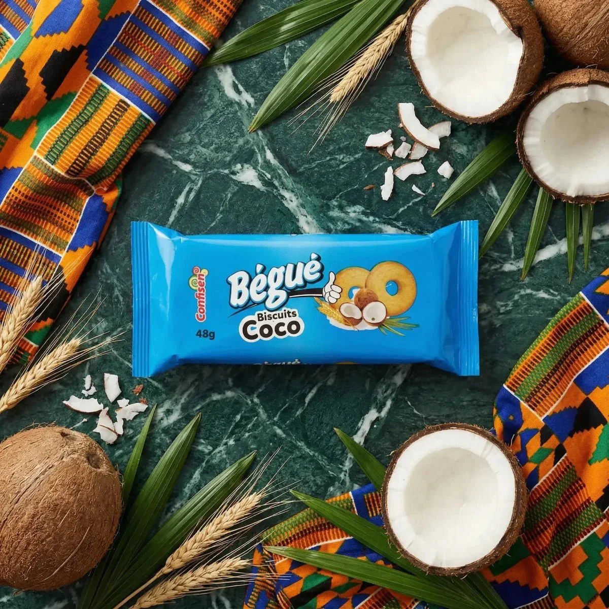 Biscotti al cocco BÉGUÉ 48g su sfondo marmo verde, noce di cocco, foglie di palma.