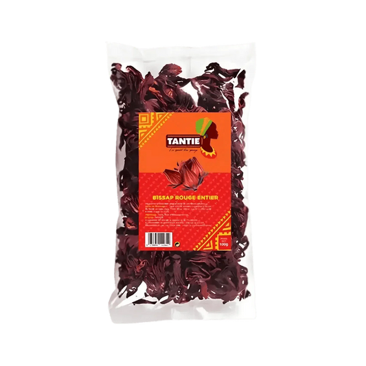 Transparant zakje met hele rode Bissap TANTIE, 100g op groene achtergrond. Oranje en rood verpakkingsmateriaal.