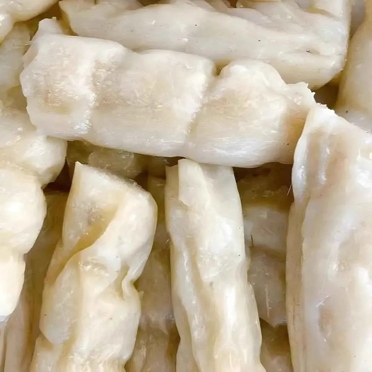 Bobolo découpé en morceaux après cuisson, texture moelleuse du manioc pilé, aliment sain et riche en nutriments pour accompagnement.