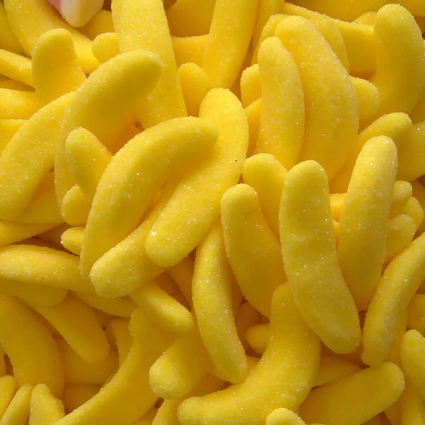 Bonbons banane jaunes, recouverts de sucre. Confiseries en forme de banane, vue rapprochée.