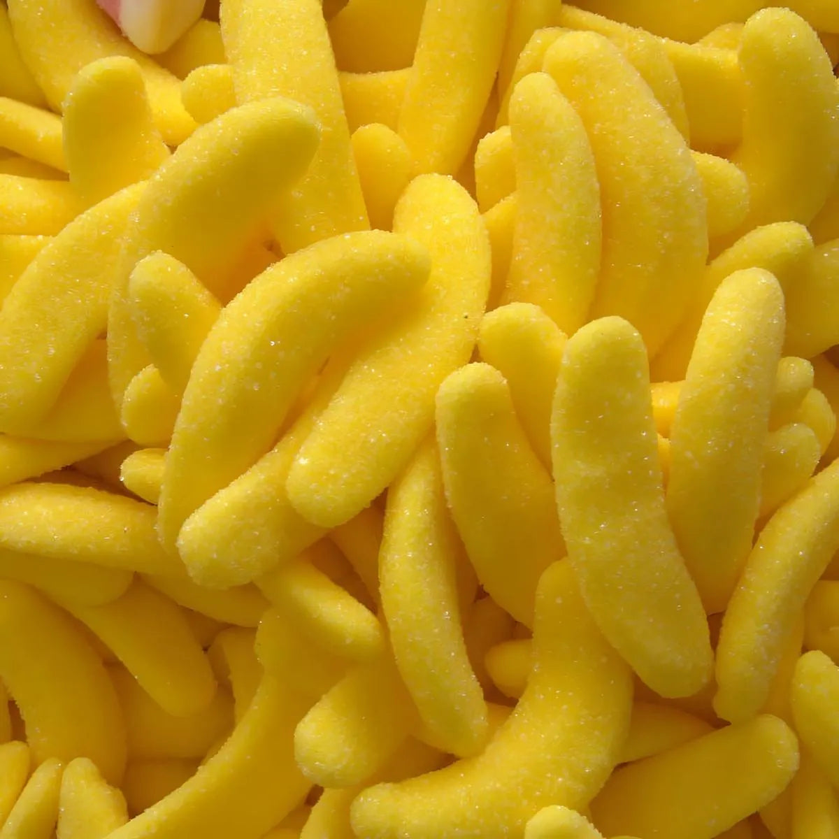 Gros plan sur les bonbons Banana Cool Halal SAMIA, texture moelleuse et enrobage sucré, saveur banane tropicale.
