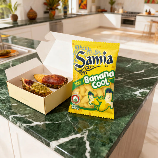 Sachet de bonbons Banana Cool Halal - SAMIA posé sur un plan de travail en marbre vert, à côté d'une boîte de douceurs orientales.