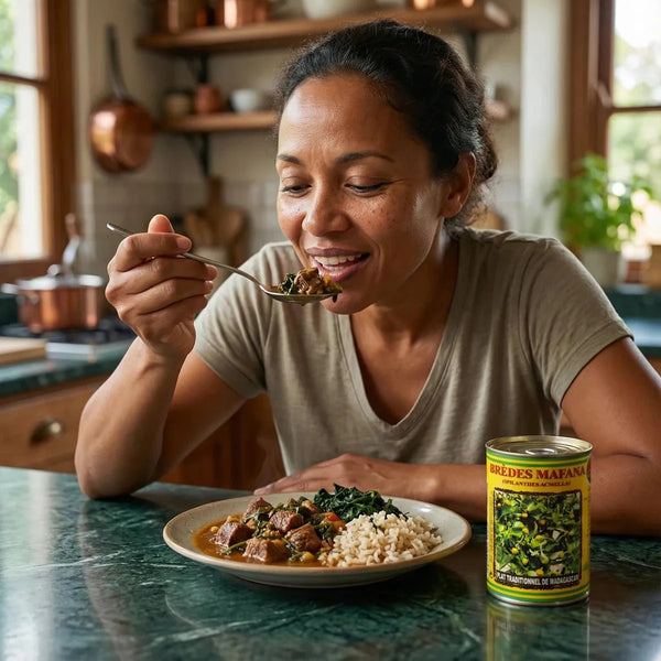 Femme mangeant Brèdes Mafana CODAL avec riz. Boîte jaune, plat malgache traditionnel.