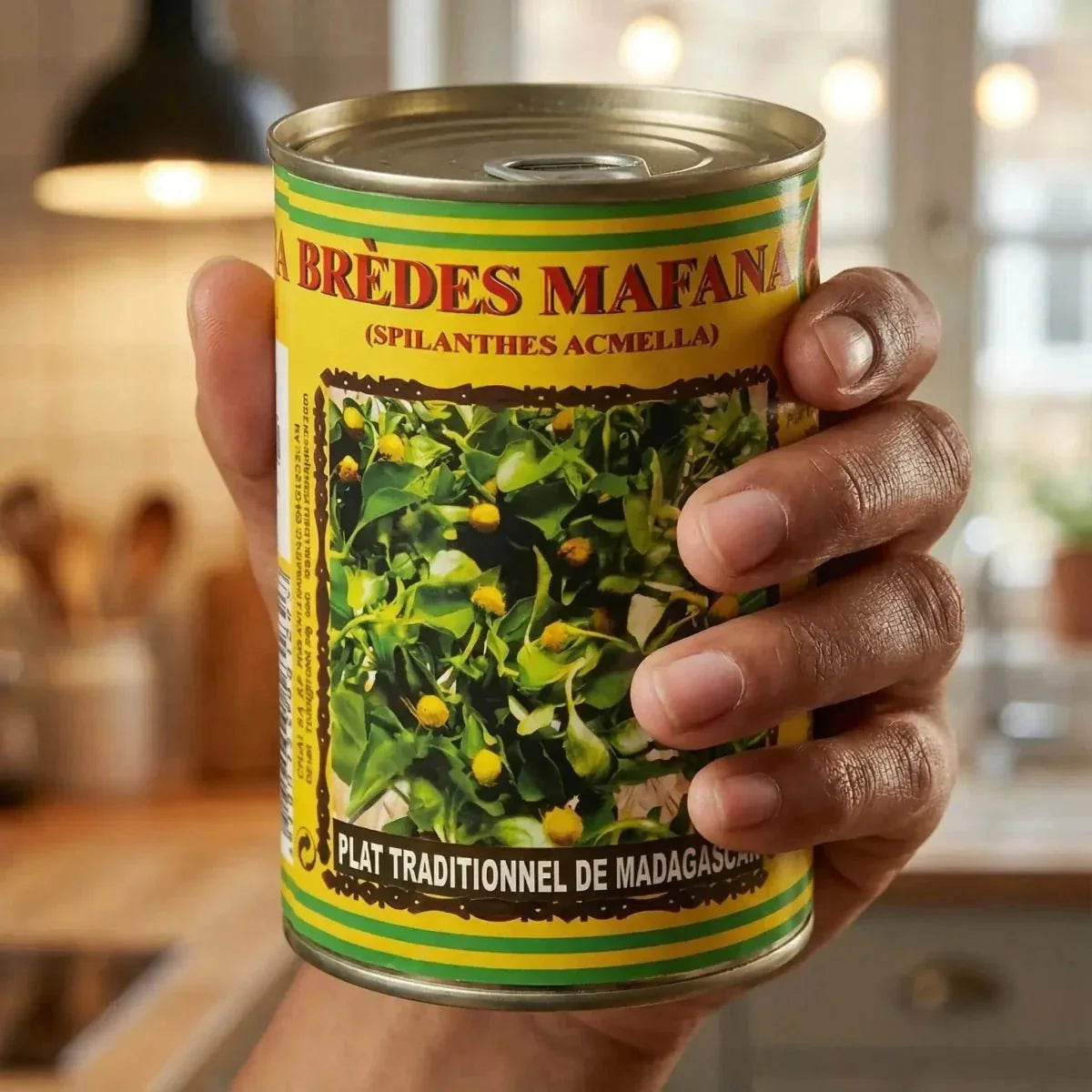 Can of mafana greens by CODAL, held in a hand against a kitchen background.