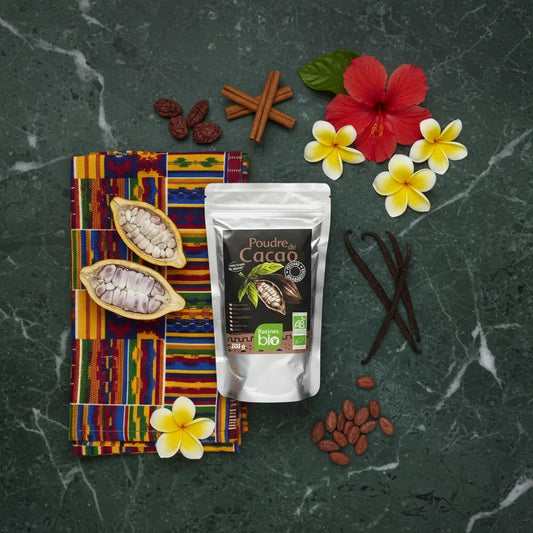 Sachet de poudre de cacao RACINES BIO entouré d'ingrédients naturels comme la vanille, la cannelle et des fèves de cacao sur fond ethnique.