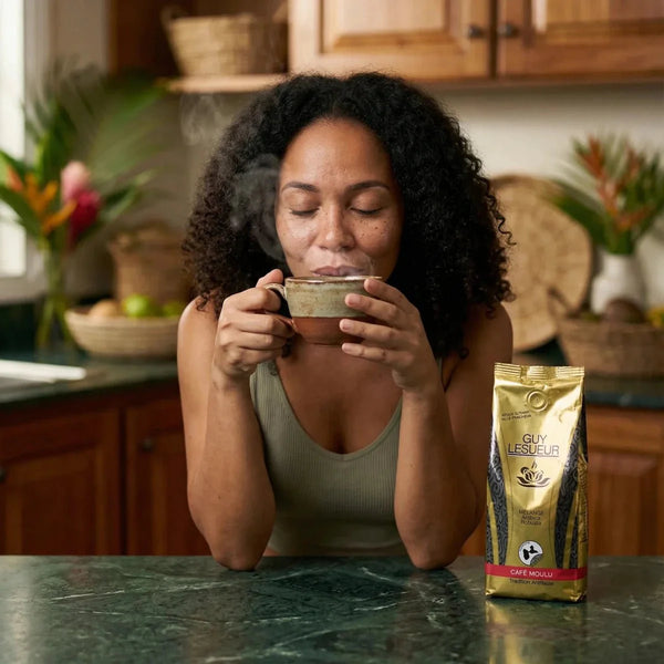 Frau genießt Guy Lesueur Kaffee. Goldene Tüte auf Marmor-Theke. Dampf, gemütliche Küche.
