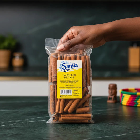 Main tenant un sachet de cannelle en bâton SAMIA, produit d’épicerie salée pour assaisonner plats et desserts.