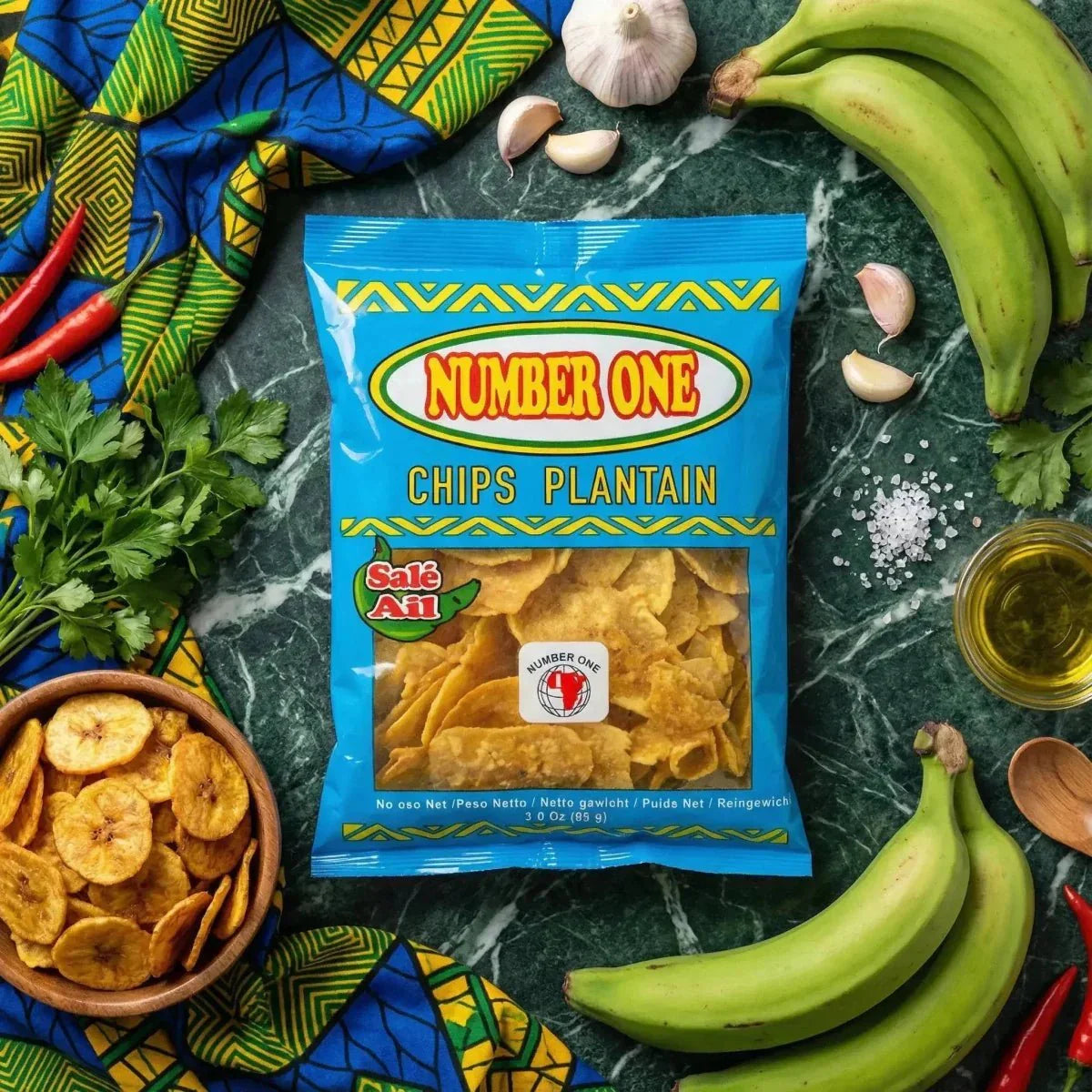 Knoflook plantainchips Nr. 1 omringd door groene plantains, peper, peterselie, kruiden.