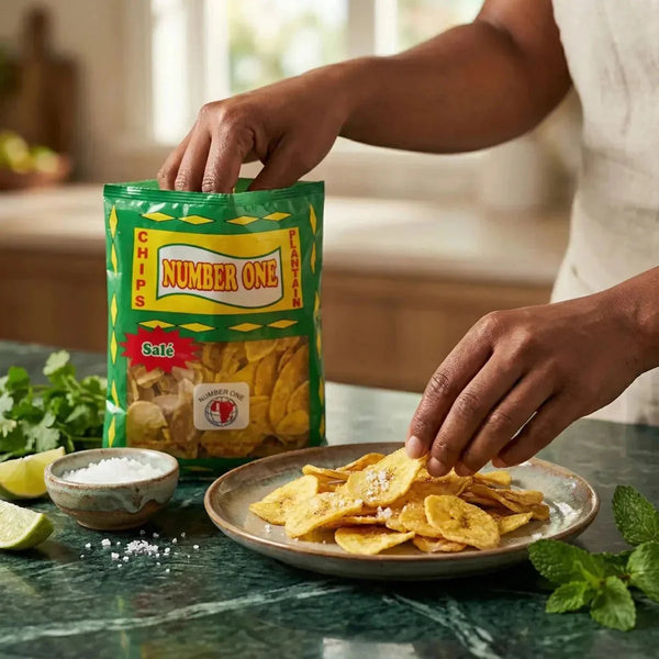 Chips plantain salées N°1 (85g). Main prenant des chips dans un sac devant une assiette remplie.