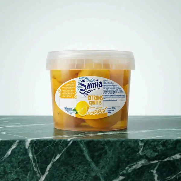 Citrons confits de la marque Samia, présentés dans un pot transparent sur un comptoir en marbre.