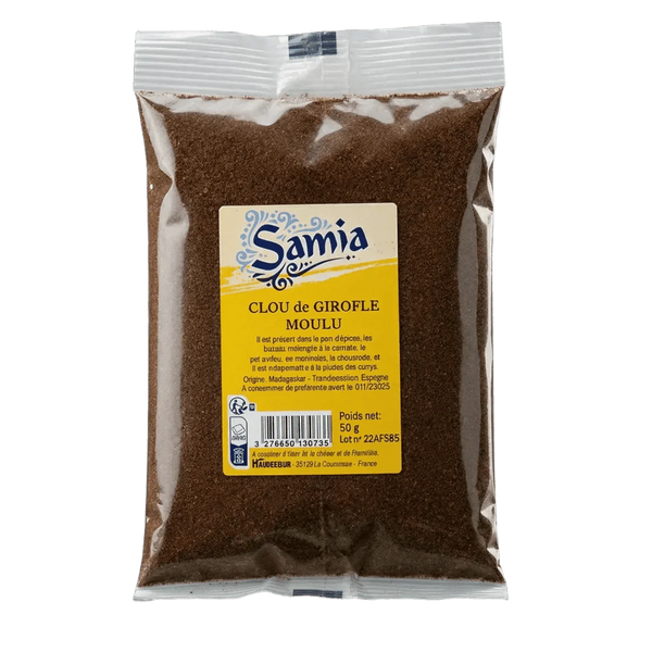 Transparent bag of ground SAMIA cloves. Close-up of the product, dark green solid background.