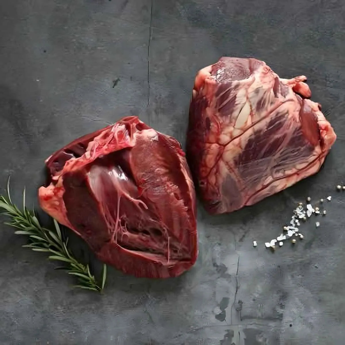 Cœur de bœuf coupé en deux, découpe uniforme pour cuisson rapide. Viande rouge surgelée accompagnée d’herbes et épices, prête à cuisiner.