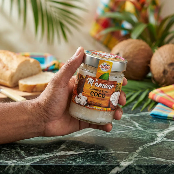 Kokosnussmarmelade M'AMOUR von Lesueur, in einem Glasgefäß, das in einer Hand gehalten wird.