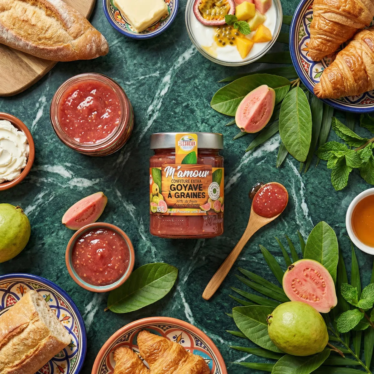 Confettura di guava M'AMOUR LESUEUR su un tavolo apparecchiato con pane, croissant, frutta fresca.