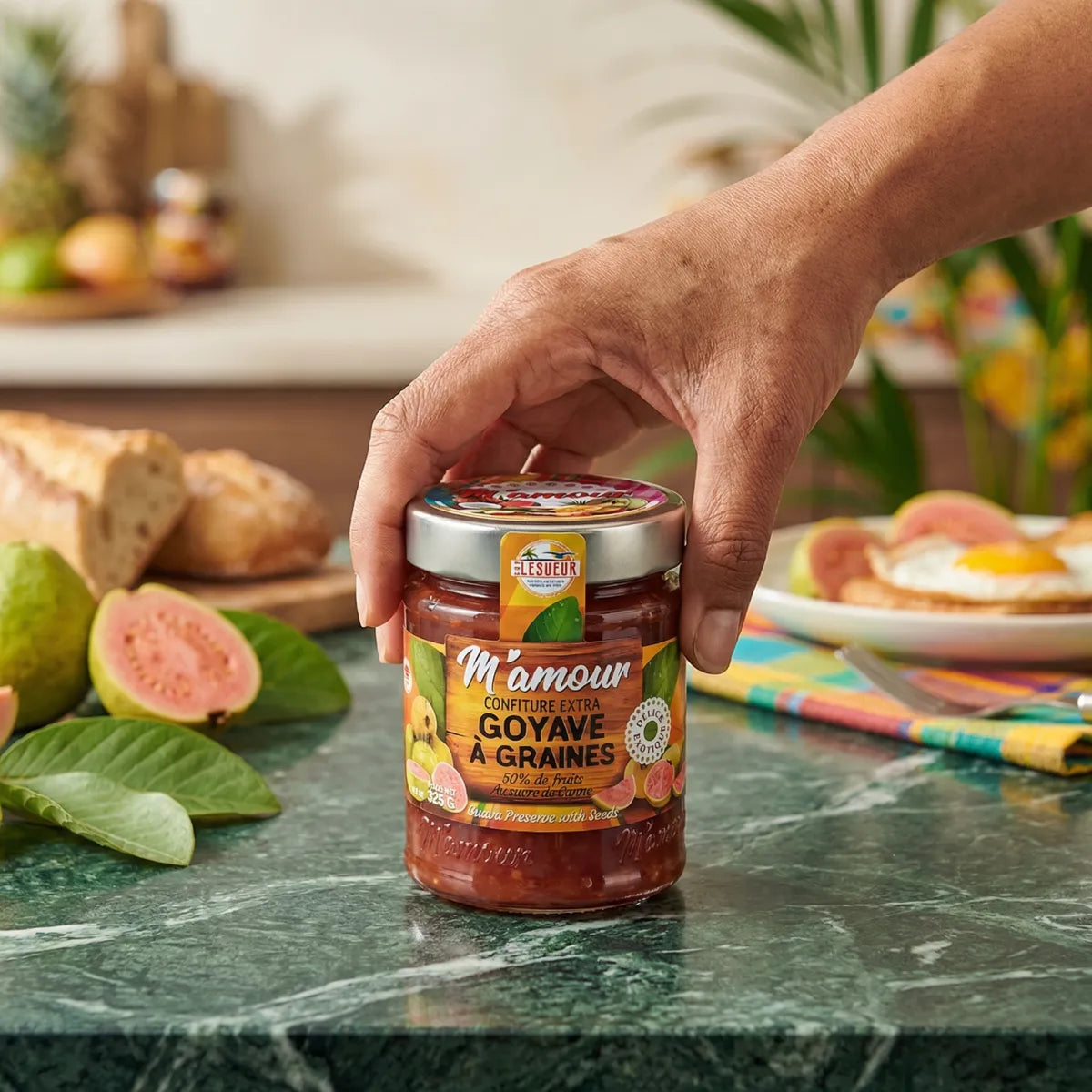 Confettura di guava con semi M'Amour di Élésueur, con frutta e pane sullo sfondo.