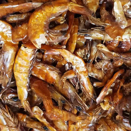 Gros plan sur crevettes fumées entières, texture brillante et couleur intense. Base idéale pour poudre de crevettes à saveur riche.