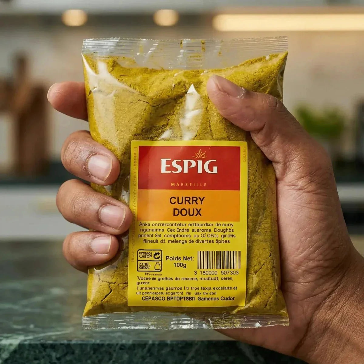 Tüte mit mildem ESPIG-Curry 100g, gehalten in einer Hand. Nahaufnahme der Produktverpackung.