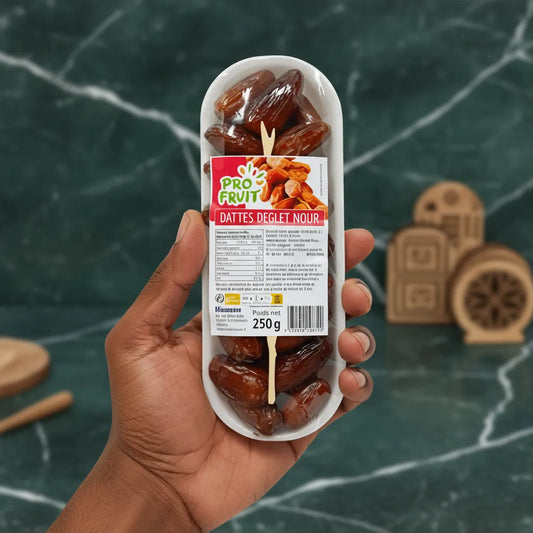 Main tenant un emballage de dates PROFRUIT Deglet Nour 250g, parfaites pour une collation saine et naturelle à emporter partout.