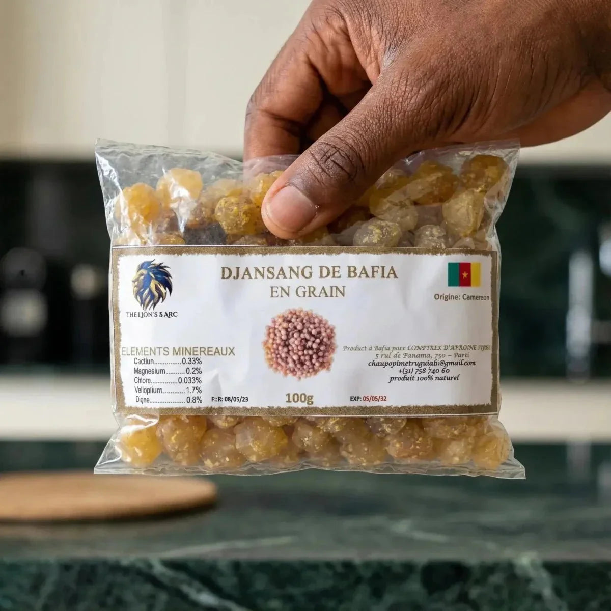 Bolsa de Djansang en grano de The Lion's Sarc sostenida por una mano. Producto de Camerún.